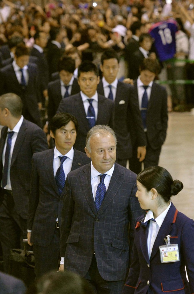 失意の中、成田空港に到着するアルベルト・ザッケローニ監督（手前から２人目）ら日本代表。到着ロビーはなぜか大きな歓声に包まれた（共同）