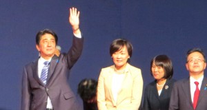 壇上で拍手に応える安倍首相と昭恵夫人