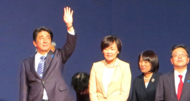 壇上で拍手に応える安倍首相と昭恵夫人