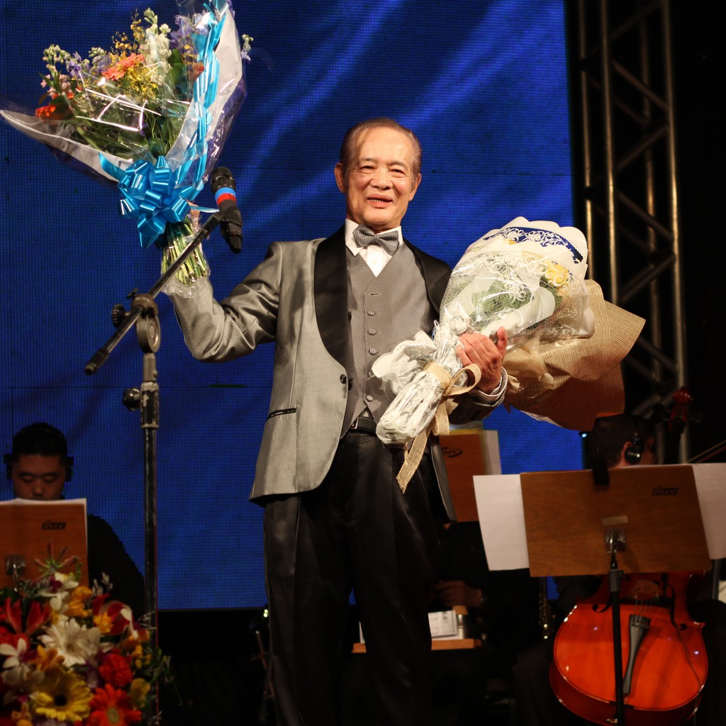 花束を手に笑顔を見せる北川名誉会長