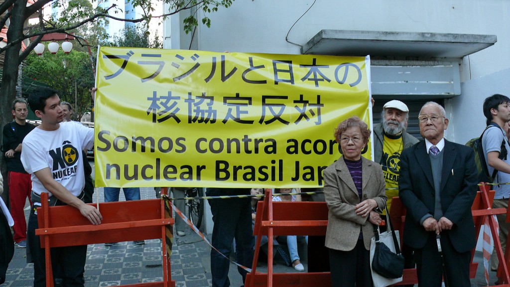 横断幕を持つ伯人運動家と森田会長（右手前）、渡辺淳子理事（その左）（写真提供は２枚ともgrupo Xo Nuclear）