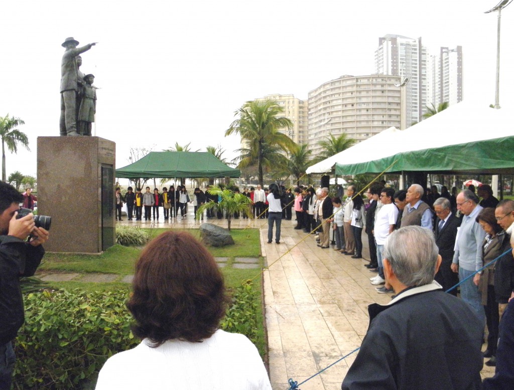 日本移民上陸記念碑を囲んで手を繋ぎ、黙祷を捧げる参加者達