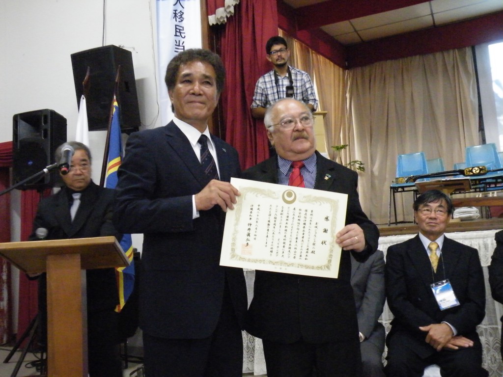 高良副知事から表彰状を受け取るカンポ・グランデ沖縄県人会の玉城ジョルジ元会長