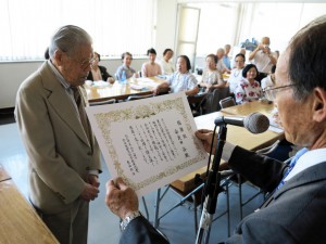 多田さんから表彰状を渡される安良田さん（左）