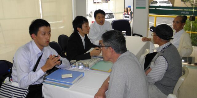 派遣団と相談する検診利用者