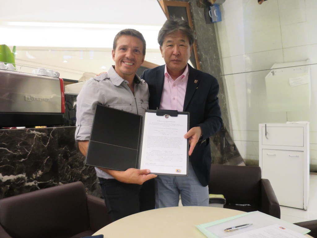 ジュニーニョ会長（左）とサインを交わした竹山理事