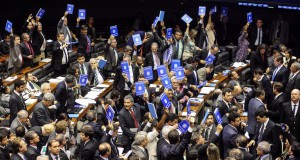 労働手帳を模した青いノートを手に承認反対の意思表示をする下議達（Gustavo Lima/Camara dos Deptados）