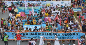 横断幕を掲げて行進に参加する黒人女性達（Marcello Casal Jr./Agência Brasil)