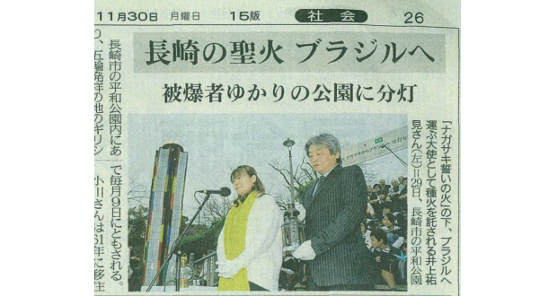 11月30日付長崎新聞。分灯式で種火を受け取った井上祐見（左）と中嶋代表