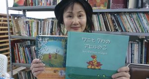 新書と前翻訳作の「ぼくのオレンジの木」を手にする松本さん