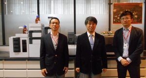 同社の製品を背に的場社長（中）、藤井崇史（左）、中峯弘揮両役員