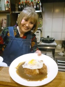 店主のマルガリーダさん（カレーの目玉焼きはオプション）