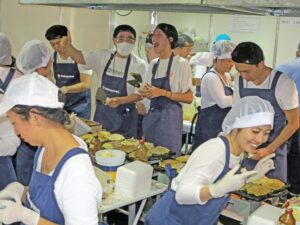 楽しそうにお好み焼きを焼く和歌山県人会の若者たち