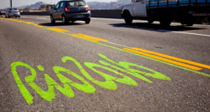 リオ２０１６の文字の横に緑の線が引かれた道路（Daniel Coelho/Seconserva）