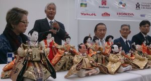 ひな人形を前にあいさつする井戸端塾の稲井理事長（左から２人目）