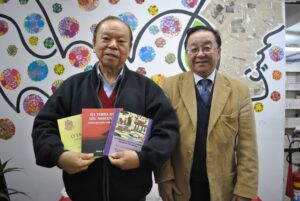 著書を手にする知念明さん（左）と宮村会長