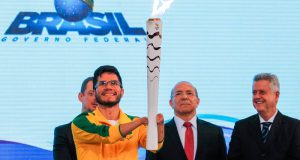 ブラジリアで再点火されたパラリンピック用の聖火を持つヨハンソン・ナシメント（２５日、Valter Campanato/Agência Brasil）