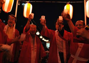 やぐらの上で乾杯！開幕を祝う（左から）山元総領事、鹿田理事長ら