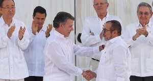 和平合意文書署名式で握手するコロンビアのサントス大統領（左）とＦＡＲＣ司令官ロンドーニョ氏（右）（JUAN PABLO BELLO/SIG）