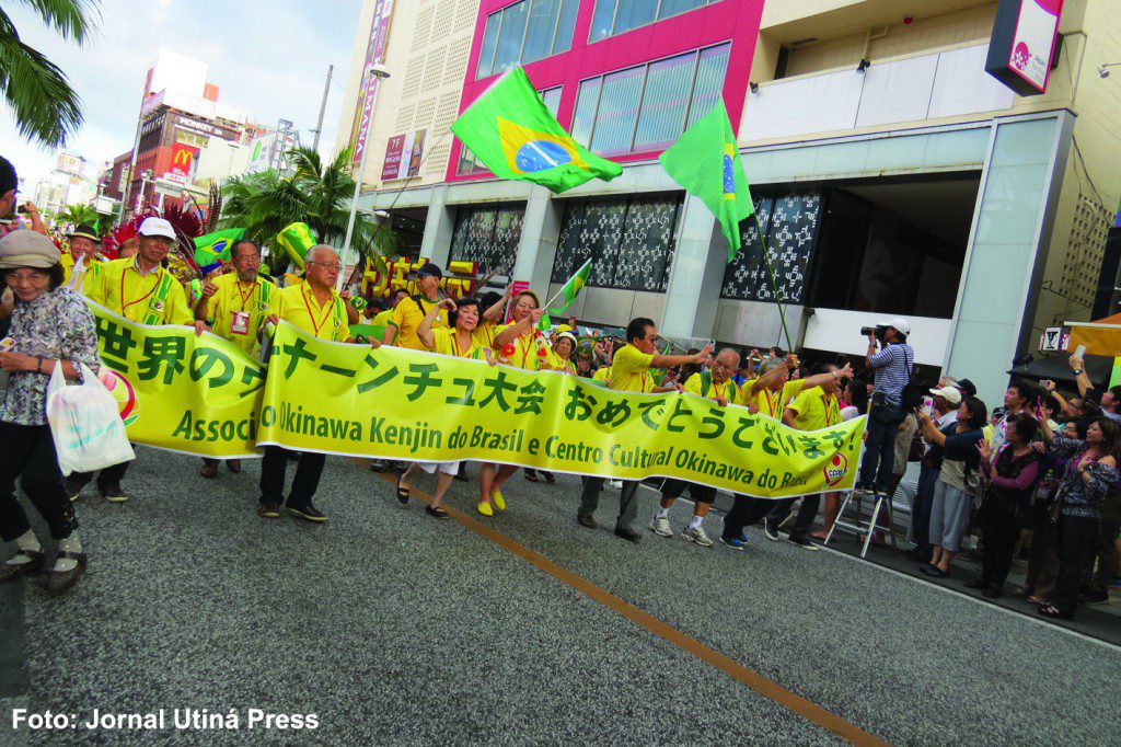 前夜祭パレードで、街道を練り歩くブラジル県人会関係者。呉屋春美文協会長、援協の与儀昭雄次期会長らも参加した（ウチナープレス提供）