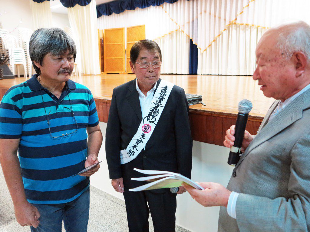 安立会長、安光さんに記念品を渡す本橋幹久団長