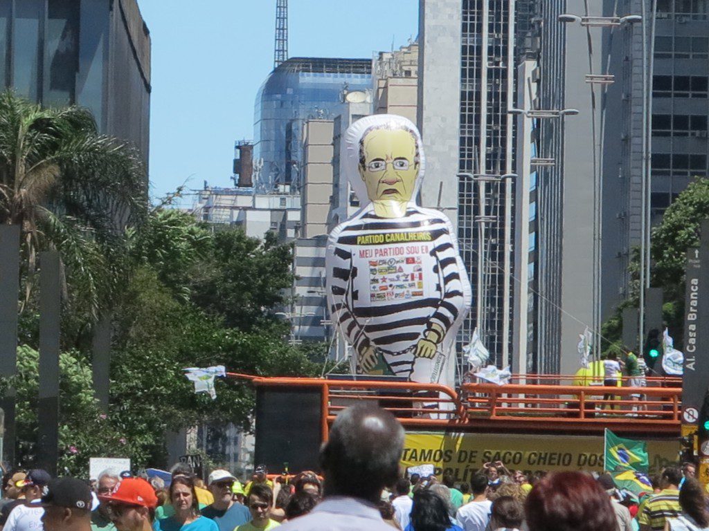 今回の〝主役〟レナン上院議長の風船人形。下には「ブラジルは悪徳政治家にうんざりだ！」とのスローガン
