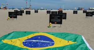 コパカバーナに設置された、流れ弾に当たってなくなった子供の碑と、銃の被害を示す、穴あきのブラジル国旗（Tomaz Silva/Agência Brasil）