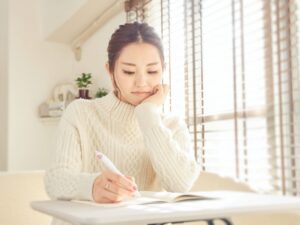 じっくりと考えながら手紙を書く女性（イメージ写真）