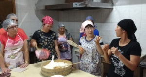 巻き寿司の作り方を指導する清水さん（右から２番目）