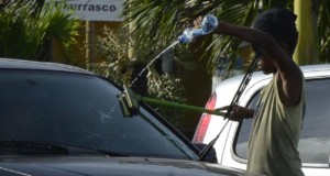 信号待ちの車に駆け寄り、「窓ガラスを拭くからお金を頂戴」とせがむ少年（参考画像・Valter Campanato/Agência Brasil）
