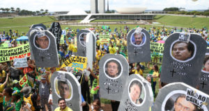 政治家や企業家の顔写真を掲げて、汚職反対デモを行う人々（Antonio Cruz/Agência Brasil）
