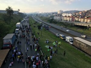 幹線道路脇に停められたトラックと路上に広がった運転手達（Roberto Parizotti）