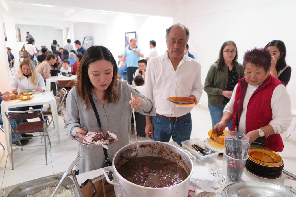 次から次へとフェイジョアーダを食べにくる会員ら