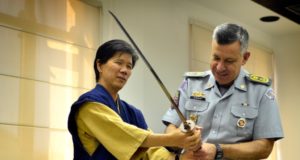 マルセロ・ヴィエイラ・サーレス大佐に日本刀を見せる岸川さん（提供写真）
