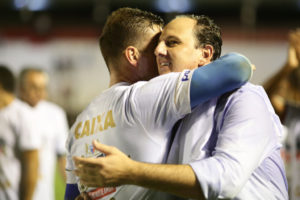 昇格を決め、選手と抱き合う、フォルタレーザのロジェリオ・セニ監督（右）（Lucas Figueiredo/CBF）