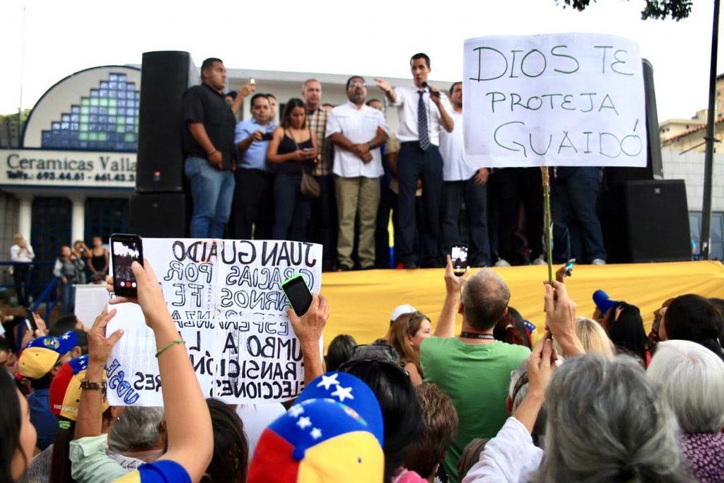 ２１日に行われた抗議行動の中で演説するグアイド議長、「神が守ってくださるように」などと書かれたプラカードも見える（Twitter）