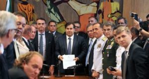 ボウソナロ大統領（中央左）と、受け取ったばかりの軍関係者年金改革法案を見せるロドリゴ・マイア議長（J.Batista / Camara dos Deptados）
