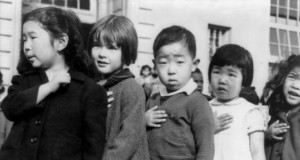 強制収容所内で、合衆国旗への「忠誠の誓い」をする子供たち（1942年4月、Photo attributed to Dorothea Lange(w). [Public domain]）