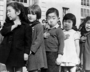 強制収容所内で、合衆国旗への「忠誠の誓い」をする子供たち（1942年4月、Photo attributed to Dorothea Lange(w). [Public domain]）