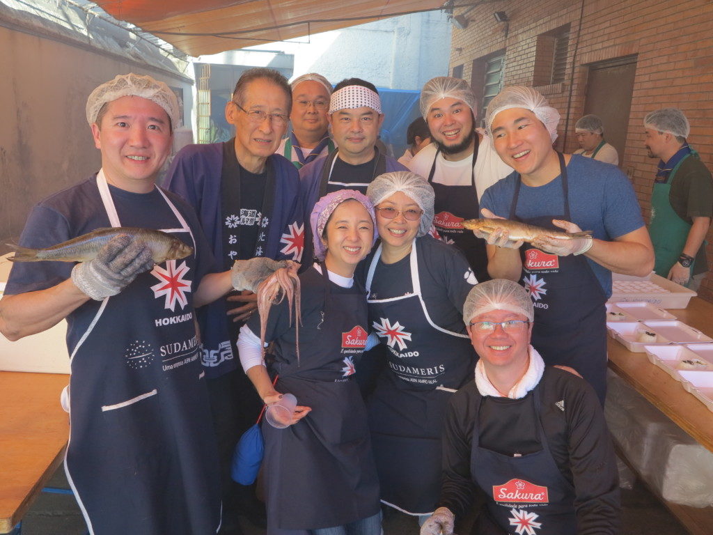 会館裏で焼き方をする青年部員らと大沼会長（左から２人目）