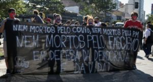 「民主主義と命を守るため」との横断幕を掲げたサンパウロ市でのデモ（７日、Guilherme Gandolfi）