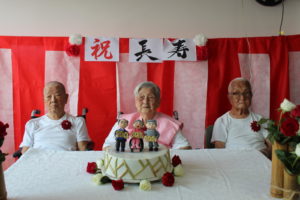 ケーキを前に記念写真を撮る３人。堀川さん、金村さん、堀越さん