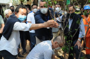 桜を植樹する野村市議（左）とサレス地区長（中央）、右が池崎会長