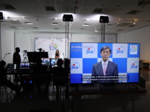 会場のテレビ画面で映し出された北岡伸一ＪＩＣＡ理事長のあいさつ